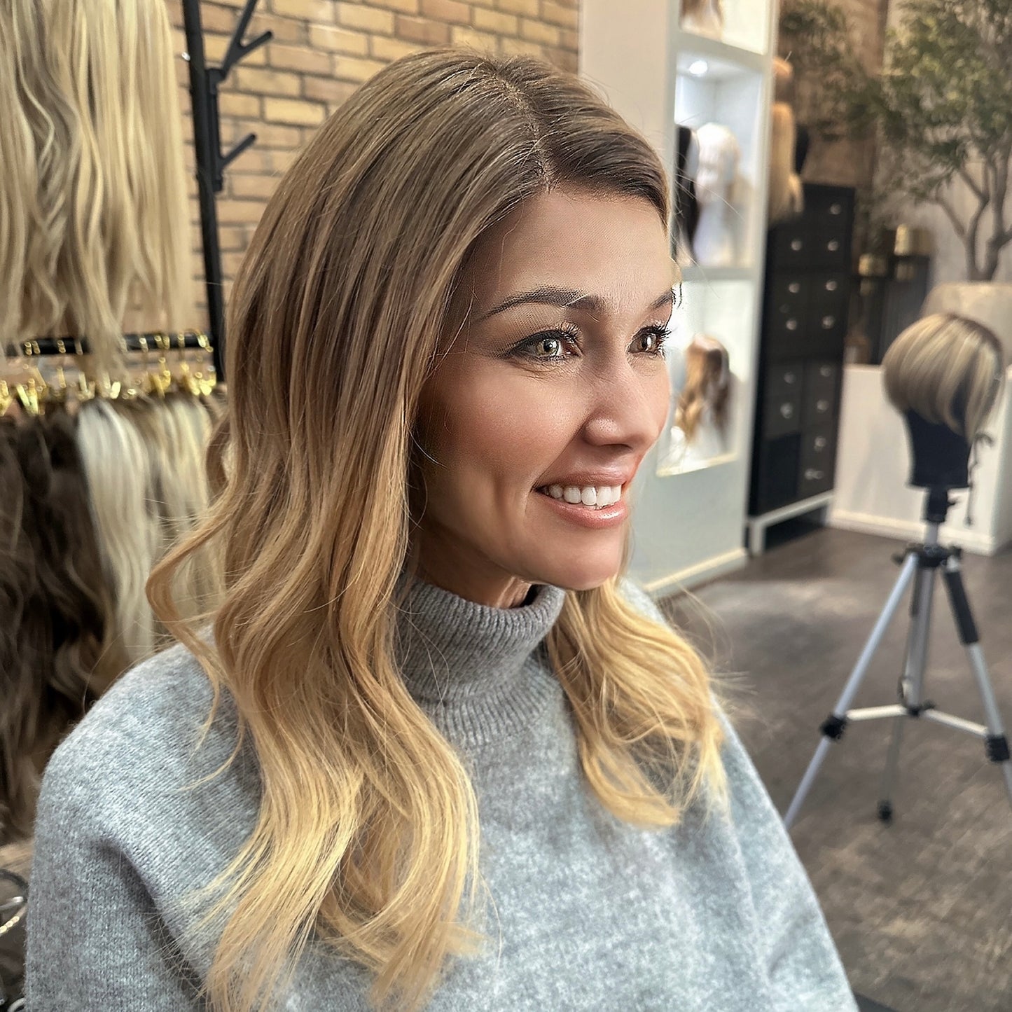 Kelly HD Wig three-quarter view – HD lace wig with natural hairline, brunette to blonde balayage blend, styled in soft waves